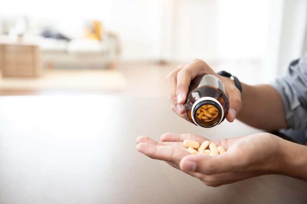 close-up-doctor-holding-frug-medicine-bottle-herbal-supplement-pill-patient-home-1-1.jpg